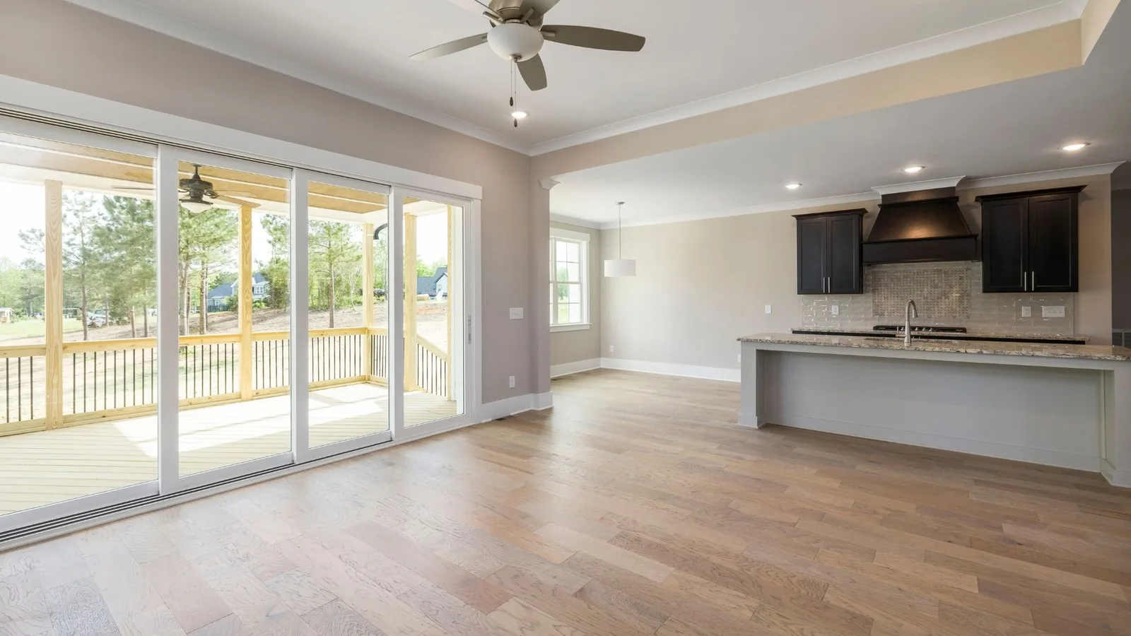 Clean open-concept room with kitchen and patio doors
