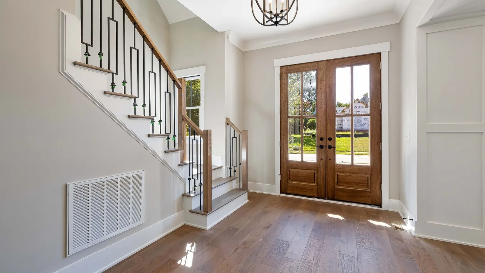 Clean foyer with staircase and front door